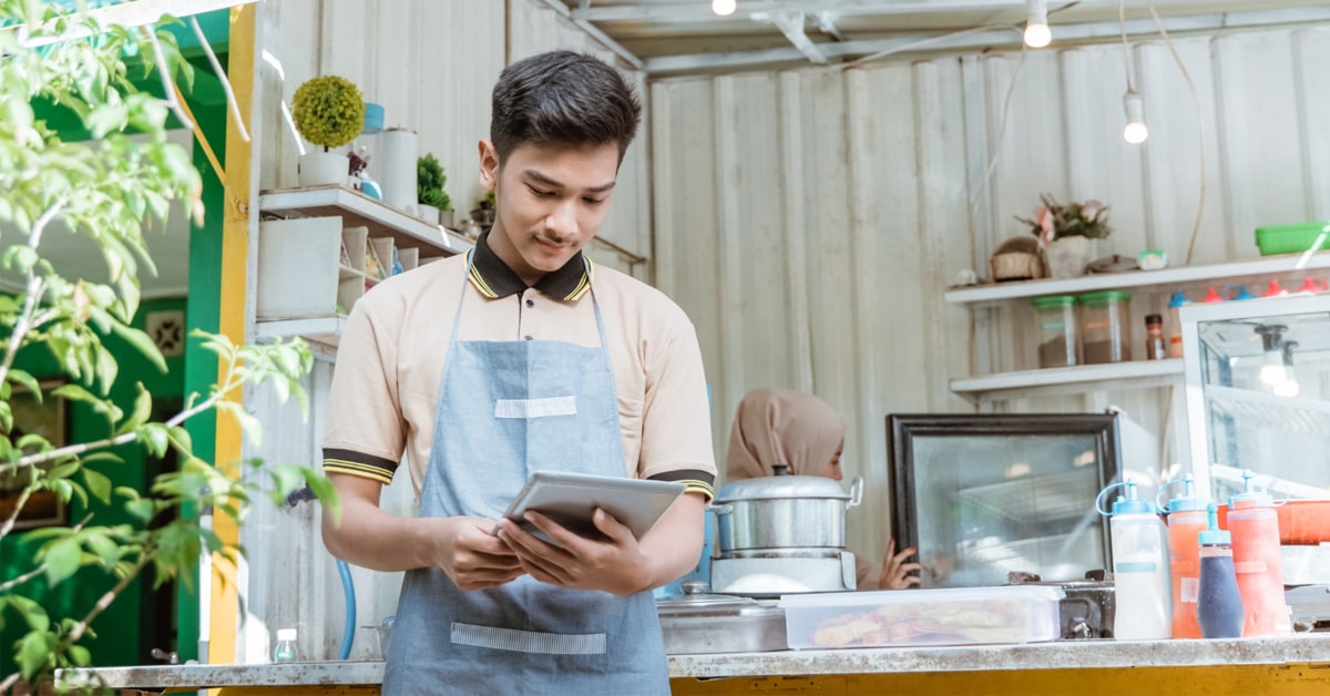 A young man operating tablet at shop